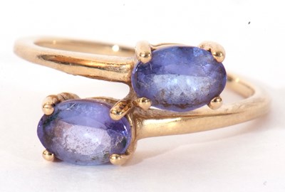 Lot 129 - Modern 9ct gold and tanzanite cross-over ring,...