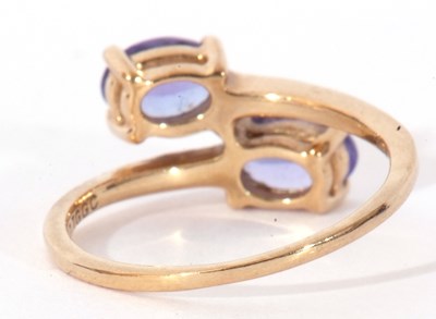 Lot 129 - Modern 9ct gold and tanzanite cross-over ring,...