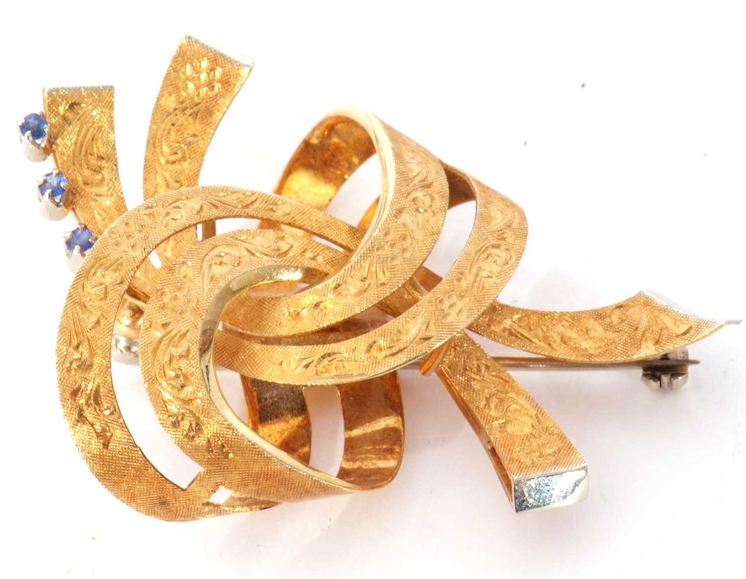 Lot 183 - A 750 stamped scroll brooch, chased and...