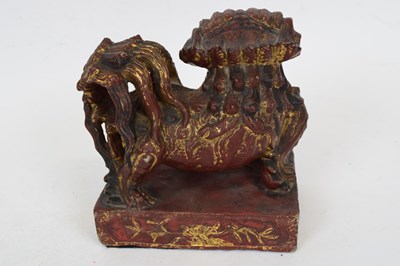 Lot 13 - Oriental stone lion with red and gilt painted...