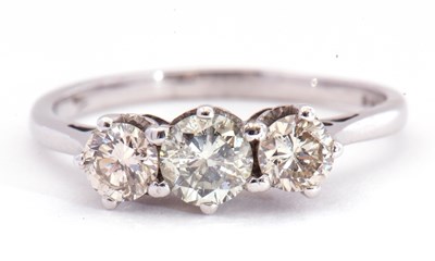 Lot 11 - A three stone diamond ring featuring three...