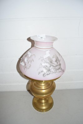 Lot 39 - Brass oil lamp, the pink shade decorated with...