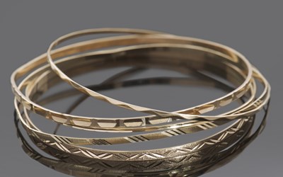 Lot 402 - Five 9ct gold bangles with engraved detail,...