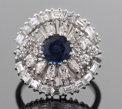 Lot 486 - A circular sapphire and diamond cluster ring...