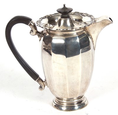 Lot 235 - George V silver hot water jug of panelled form,...