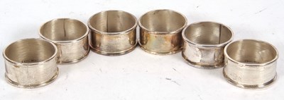 Lot 244 - A group of six serviette rings of plain...