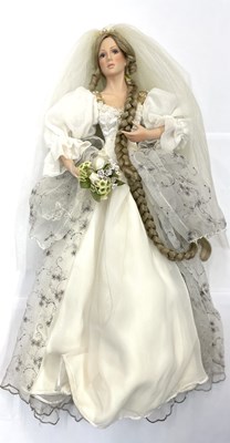 Lot 121 - A porcelain doll on stand, formed as a bride,...