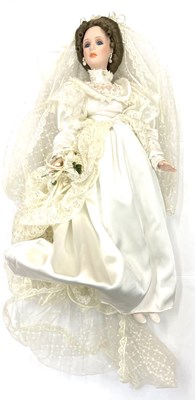 Lot 118 - A porcelain doll formed as a bride, in white...