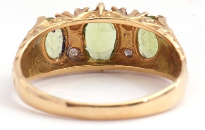Lot 76 - Modern peridot and diamond ring featuring...