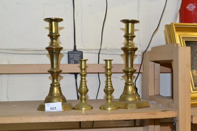 Lot 523 - Two pairs of brass candlesticks