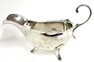 Lot 11 - White metal sauce boat with card cut rim...