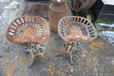 Lot 478 - Pair of iron bar stools with tractor style seats