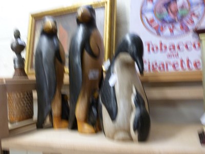 Lot 563 - Three modern wooden models of penguins