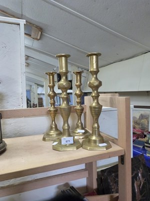 Lot 671 - Two pairs of brass candlesticks