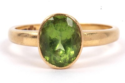 Lot 104 - An 18ct gold and peridot ring, the oval cut...