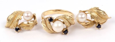 Lot 235 - A modern pearl and sapphire ring set in a...