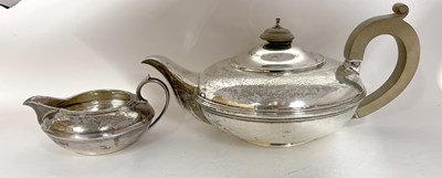 Lot 24 - A George V silver teapot and cream jug of...