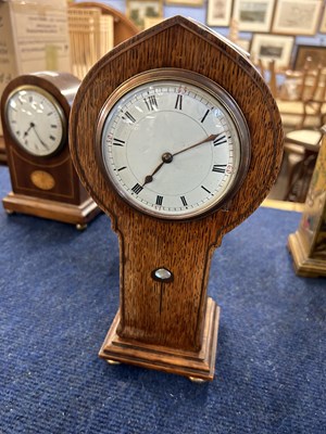 Lot 428 - A Art Nouveau shaped oak mantel clock with key