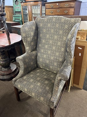 Lot 631 - A Georgian style wing back armchair with...