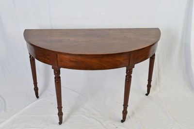 Lot 317 - Georgian mahogany demi-lune hall table raised...