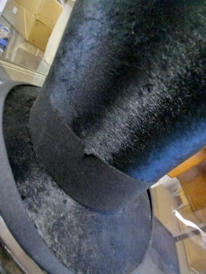 Lot 147 - A black silk top hat by Henry Heath Ltd.,...