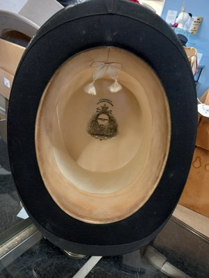 Lot 147 - A black silk top hat by Henry Heath Ltd.,...
