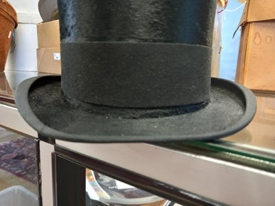 Lot 147 - A black silk top hat by Henry Heath Ltd.,...