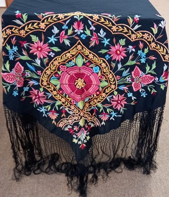 Lot 9 - A black silk embroidered shawl, with central...