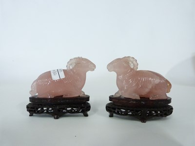 Lot 265 - Pair of pink jade rams on wooden bases, 9cm long