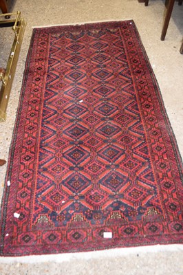 Lot 311 - A red ground rug, approx 204cm long