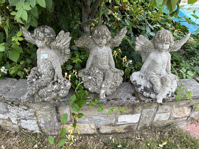 Lot 51 - Three small matching garden statues formed as...