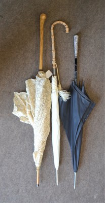 Lot 95 - A lace parasol with bamboo handle, a black...