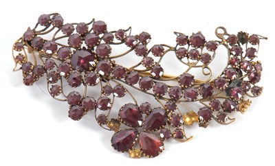 Lot 87 - An adapted garnet brooch, the curled floral...